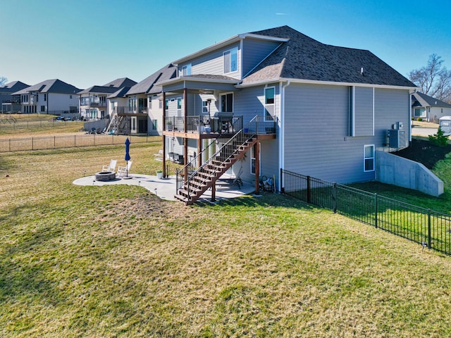 rear view of house featuring a deck, a fenced backyard, stairway, a yard, and a fire pit