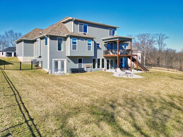 rear view of house with a yard, a fenced backyard, stairs, and a patio area