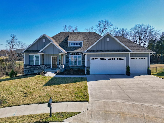 craftsman-style home with board and batten siding, a front lawn, concrete driveway, roof with shingles, and a garage