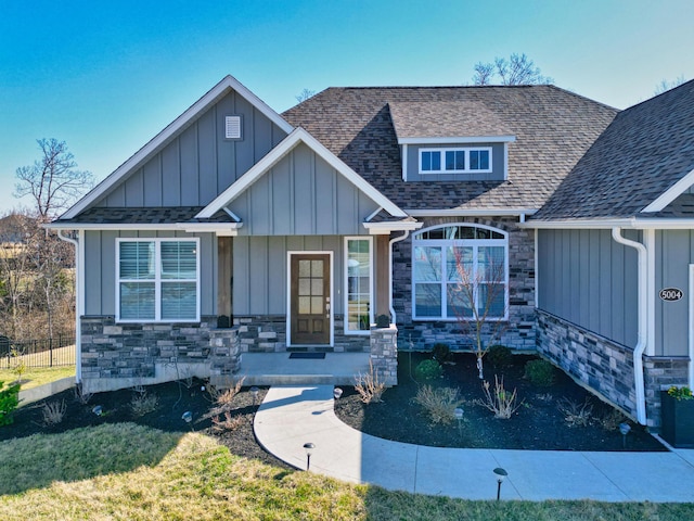 craftsman-style home featuring stone siding, board and batten siding, and a shingled roof