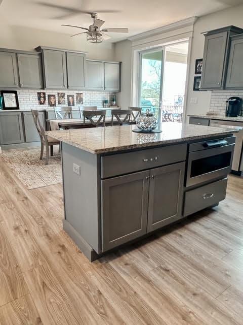 kitchen with light wood-style floors, a kitchen island, and gray cabinetry