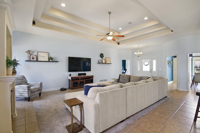 living room with a raised ceiling, light tile patterned flooring, baseboards, and visible vents