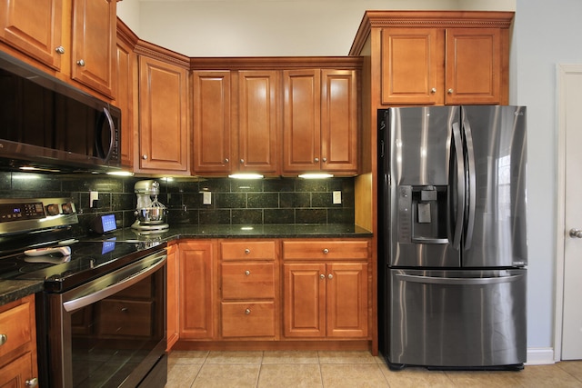 kitchen featuring stainless steel appliances, backsplash, light tile patterned flooring, and brown cabinetry