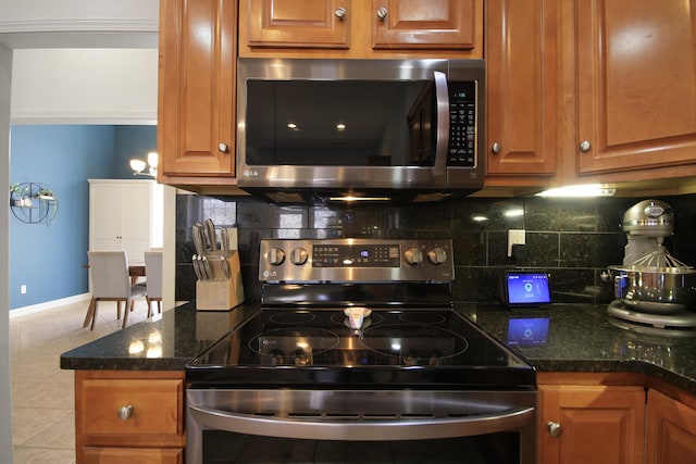 kitchen with tile patterned flooring, brown cabinetry, backsplash, and stainless steel appliances