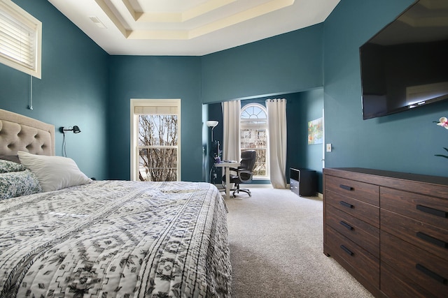 bedroom featuring a tray ceiling, carpet, and a towering ceiling