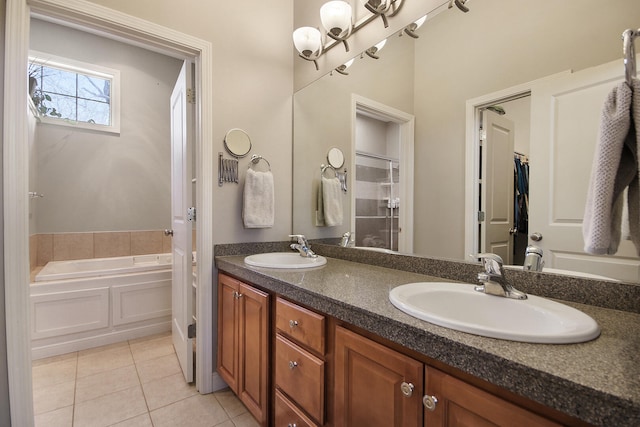 bathroom with tile patterned floors, double vanity, a garden tub, and a sink