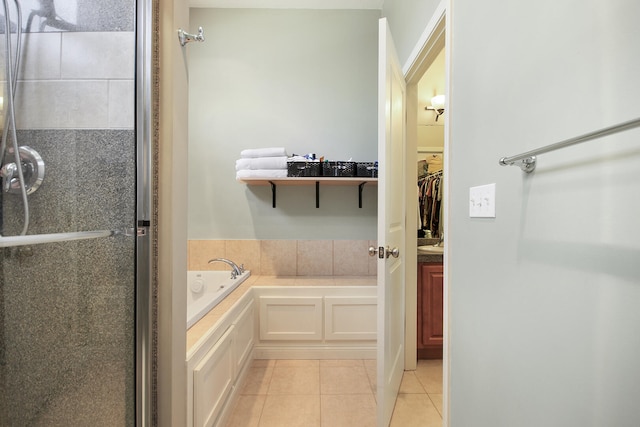 full bath featuring tile patterned floors, a spacious closet, a bath, and a stall shower