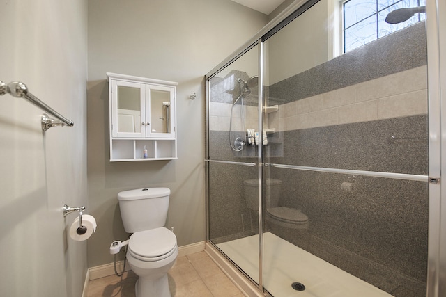 full bathroom featuring tile patterned flooring, toilet, baseboards, and a stall shower