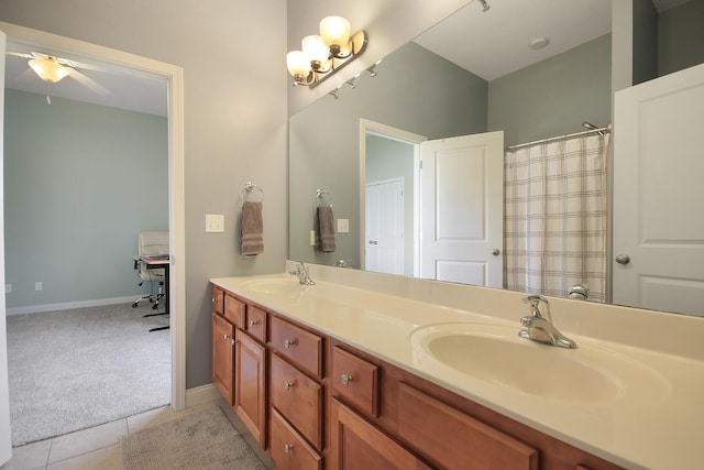 full bathroom with a sink, baseboards, double vanity, and tile patterned floors