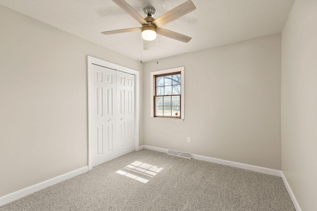 unfurnished bedroom with carpet, visible vents, a closet, and baseboards