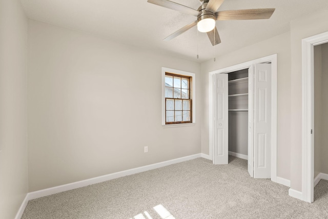 unfurnished bedroom with a closet, baseboards, light colored carpet, and a ceiling fan