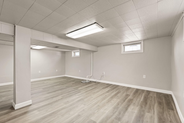 below grade area featuring baseboards and light wood-style floors