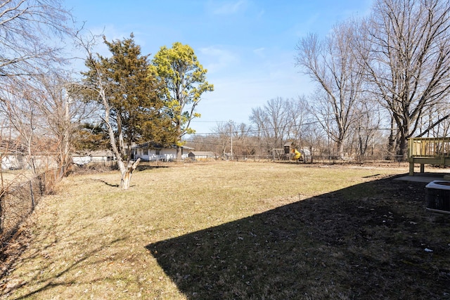 view of yard featuring fence and central AC