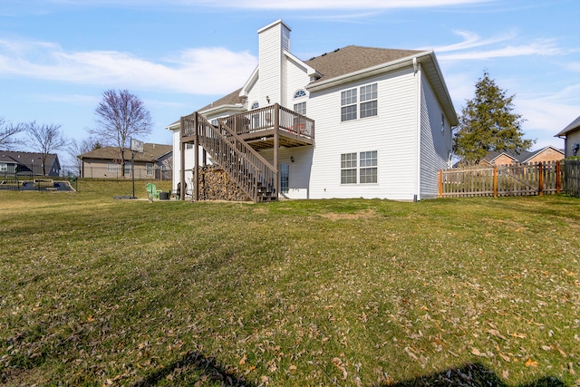 rear view of property featuring stairway, a fenced backyard, a chimney, a deck, and a lawn