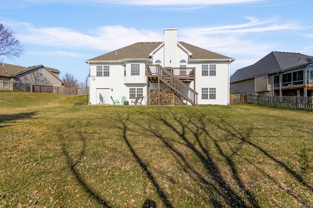 back of house featuring a fenced backyard, stairs, a yard, a wooden deck, and a chimney