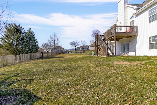 view of yard with a fenced backyard, a deck, and stairs