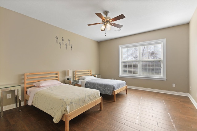 bedroom featuring ceiling fan, visible vents, baseboards, and wood finished floors