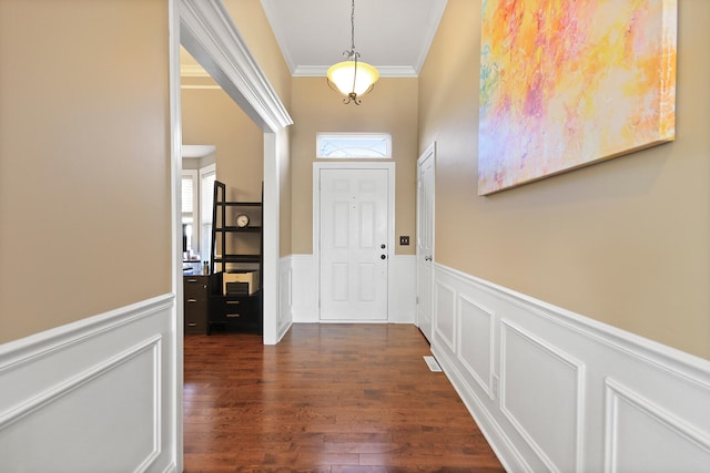 interior space with dark wood-style floors, a wainscoted wall, and ornamental molding