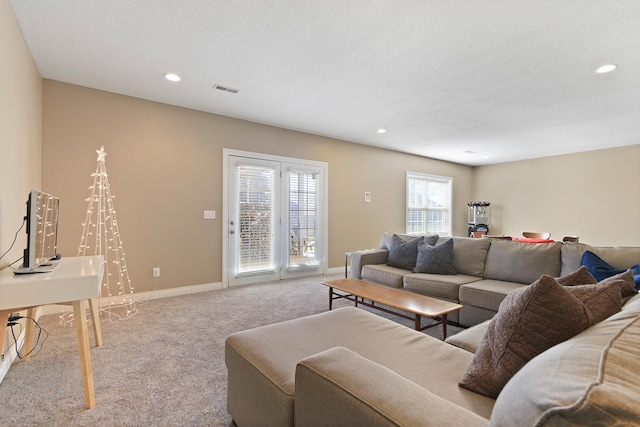 living area with visible vents, a textured ceiling, recessed lighting, carpet floors, and baseboards