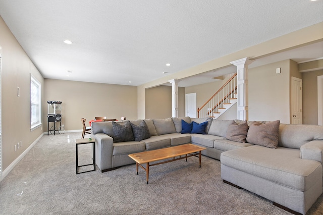 carpeted living room featuring stairway, baseboards, decorative columns, recessed lighting, and a textured ceiling