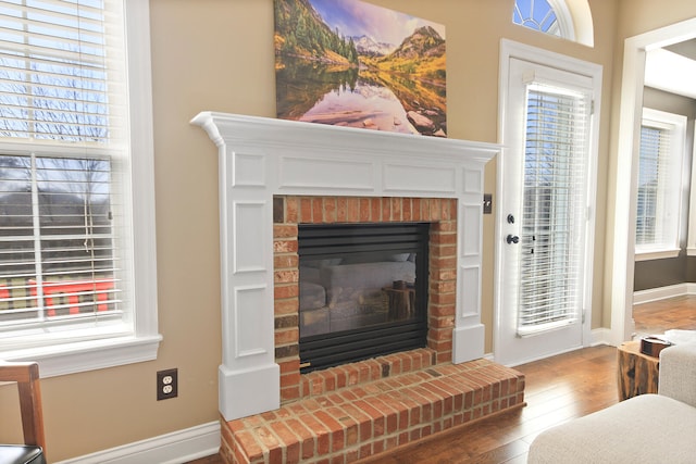 details with a brick fireplace, baseboards, and wood finished floors