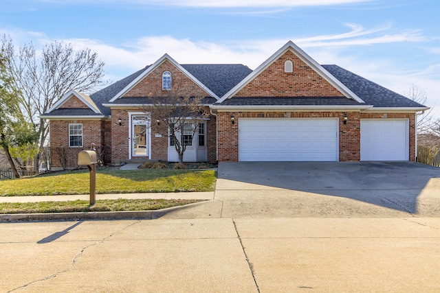 traditional home featuring brick siding, an attached garage, roof with shingles, a front yard, and driveway