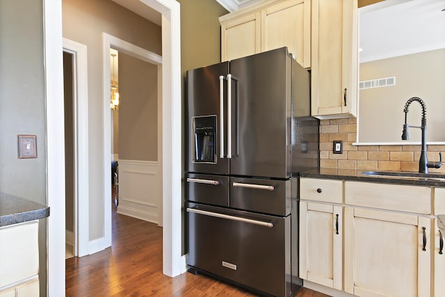 kitchen featuring dark countertops, high quality fridge, visible vents, and a sink