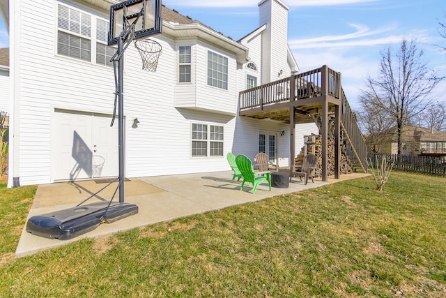 back of house featuring fence, a yard, a wooden deck, stairs, and a patio area