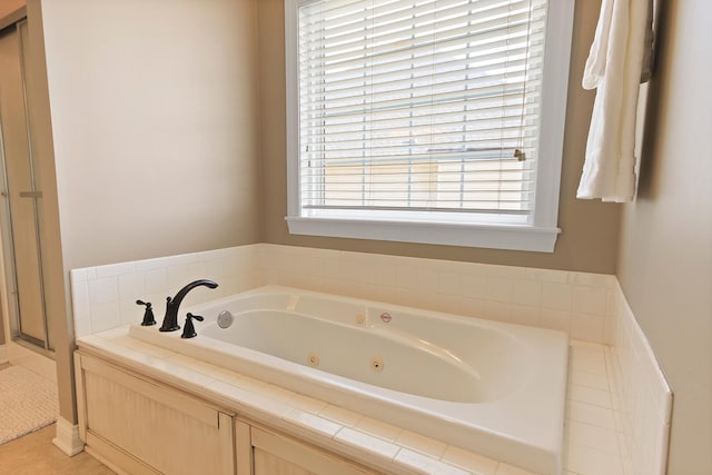 full bathroom with a shower stall and a tub with jets