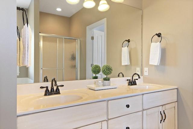 full bathroom with double vanity, a stall shower, and a sink