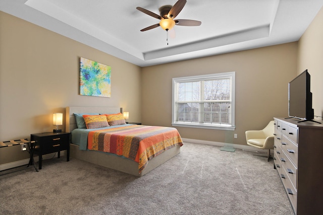 bedroom with carpet flooring, a ceiling fan, a raised ceiling, and baseboards