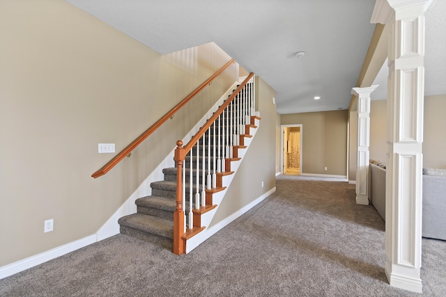 staircase with baseboards, carpet flooring, and ornate columns