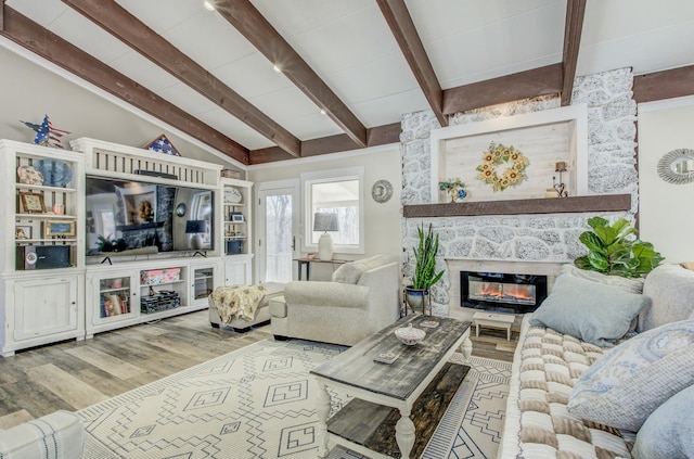 living room featuring a large fireplace, wood finished floors, and vaulted ceiling with beams