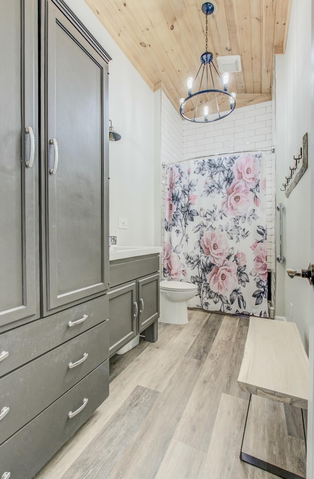 bathroom featuring wood finished floors, toilet, wood ceiling, and a chandelier