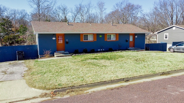 ranch-style house featuring entry steps, a front lawn, and fence