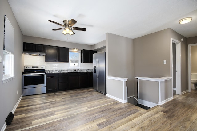 kitchen featuring under cabinet range hood, light wood-type flooring, appliances with stainless steel finishes, and a sink