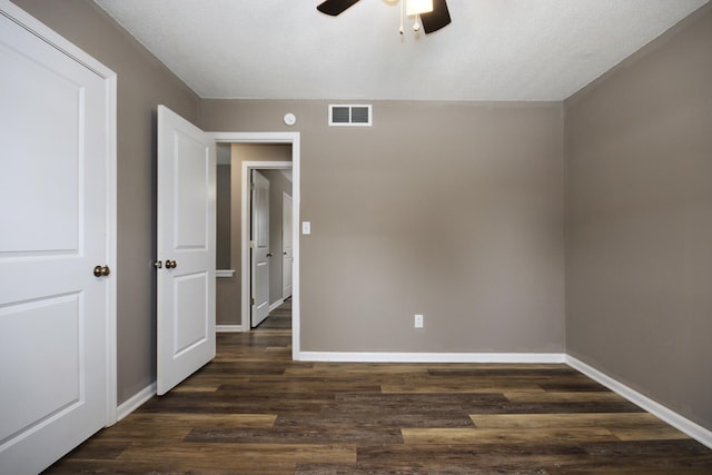 unfurnished bedroom featuring baseboards, visible vents, and dark wood-style flooring