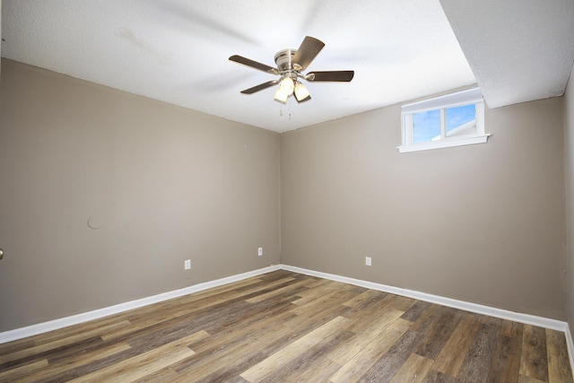 empty room featuring a ceiling fan, wood finished floors, and baseboards