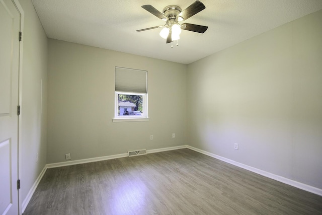 spare room featuring visible vents, a textured ceiling, dark wood-style floors, baseboards, and ceiling fan