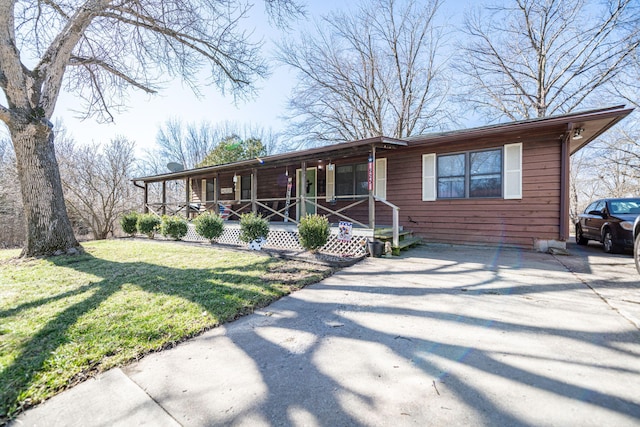 view of front of house with a porch, a front yard, and driveway