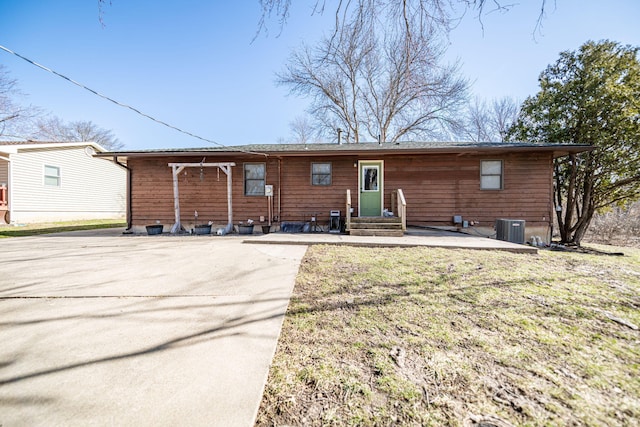 back of house featuring a lawn and central AC