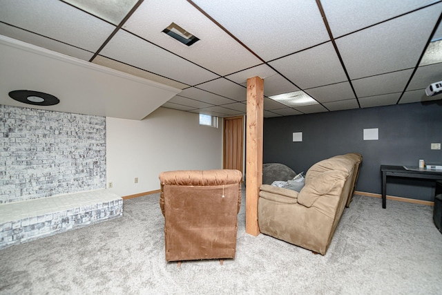 carpeted living area with baseboards and a drop ceiling