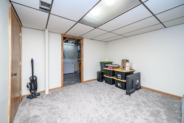 finished basement featuring a drop ceiling, baseboards, and carpet