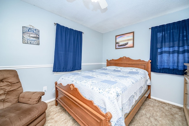 carpeted bedroom featuring baseboards, a textured ceiling, and a ceiling fan