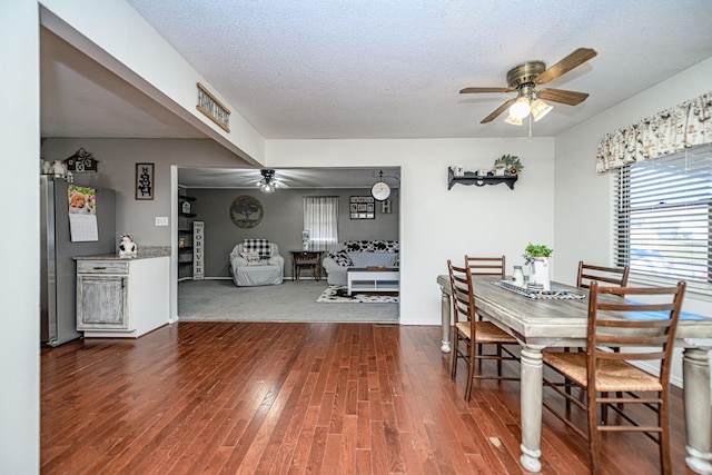 dining room with wood finished floors, a textured ceiling, and ceiling fan