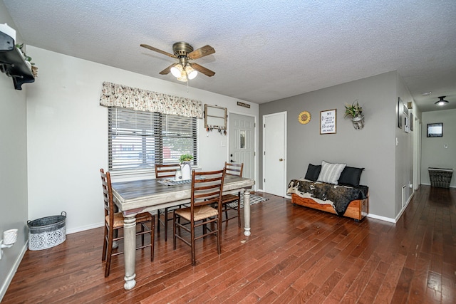 dining room featuring baseboards, a textured ceiling, wood finished floors, and a ceiling fan