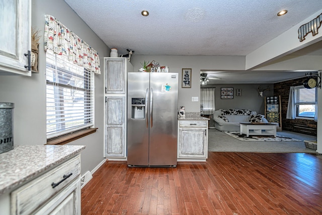 kitchen with visible vents, stainless steel fridge, a textured ceiling, and dark wood-type flooring