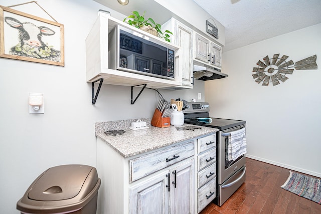 kitchen featuring baseboards, dark wood finished floors, stainless steel range with electric cooktop, under cabinet range hood, and a textured ceiling