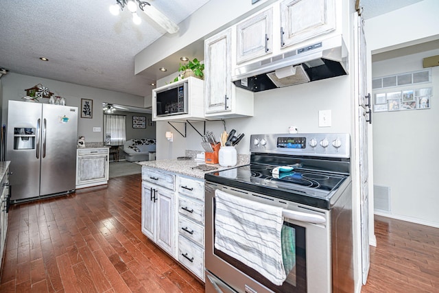 kitchen with visible vents, a ceiling fan, under cabinet range hood, a textured ceiling, and stainless steel appliances