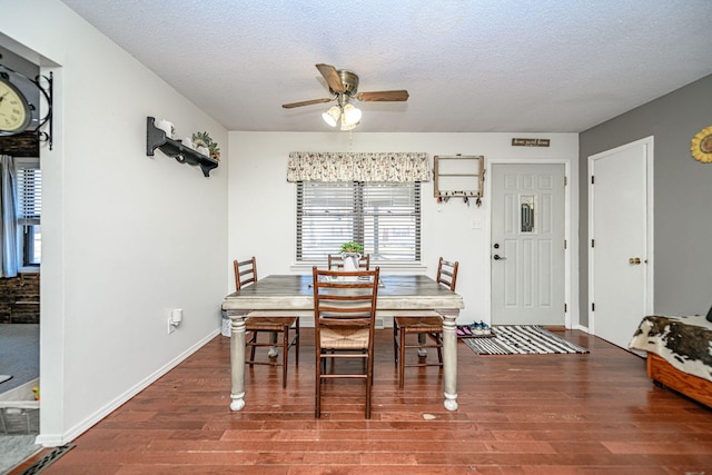 dining room with ceiling fan, a textured ceiling, baseboards, and wood finished floors